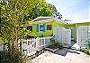 Entry into cottage through saloon-type swinging doors into a small patio/courtyard and outdoor shower.