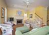The living room area features a TV and lots of seating. The living room stairs leads to the upstairs bedroom.