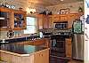 Kitchen is equipped with Stainless Steel Appliances with accesss to the dining table and extra seating provided at the bar.