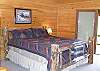 King Size Log Bed in the Master Bedroom, on the upper level, with private deck and adjoining bathroom.