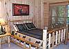 Queen Size Log Bed in the Down Stairs bedroom with access to the family room and the Hot Tub Patio