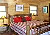 King Size Log Bed located upstairs in the Master Bedroom offers access to the private covered deck.  In the adjacent Master Bath enjoy the jacuzzi tub and walk in shower.