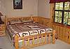 The second bedroom also located on the lower level of the cabin has a Queen Size Log Bed with an additional set of Bunk Beds which provides extra sleeping area for your children.