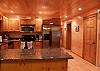 The kitchen is furnished with stainless steel appliances and granite counter tops.  2 Bar Stools are located at the kitchen bar and the dining room table provides seating for up to 4 also