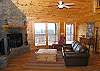 The Living Room of the Cabin is situated aroung the woodburning fireplace.  This view shows you the front door access to the covered porch.