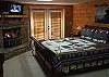 The Master Bedroom which has a King Size Bed is located on the lower level of the cabin.  Enjoy a cozy romantic evening by the gas burning fireplace, Direct TV and even a view of the  mountains from the double doors that leads out to the private screened  Hot Tub Deck.