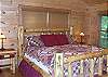 King Size Log Bed in the Master Bedroom with private bathroom with jacuzzi tub and tile walk in shower and private coffee porch.