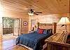 The Main Floor Bedroom is decorated with a western style motif. There is a Queen Bed and offers access to outside deck and mountain view.