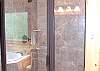 Master Bath has a custom tile walk in shower, jacuzzi tub, and vanity with double sinks.