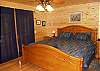 King Bed located in main level bedroom with access to the front covered porch.