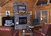 Leather Sofa and Chair for a relaxing night around the gas log fireplace and Sattelite TV the french doors provides access to the front deck where you will find rocking chairs and the Hot Tub.