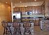 In the game room area there is a wet bar/kitchenette with stainless steel refrigerator, microwave and wine cooler for your entertainment.