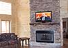42" LCD Flatscreen TV is mounted on the mantle above the gas log fireplace which is the focal point of the living room.