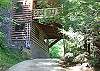 The driveway passes under the front deck of the cabin.