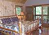 King Size Log Bed in the Master Bedroom with access to a private screened porch and Master Bath with Jacuzzi Tub and Shower.
