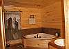 The master bath is located on the upper level of the cabin and offers a relaxing jacuzzi tub and a walk in shower also.
