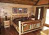 King Size Log Bed in the Master Bedroom with access to private deck.