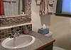 See tub/shower combo reflected in mirror.