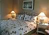 Master Bedroom with King bed, attached bathroom and sliding door to patio