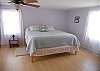 Upper level master bedroom with reading niche, pool views and windows facing the lake