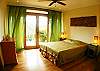 Fourth bedroom with Queen bed, wood flooring, walk-in closet, ensuite bathroom and view of the mountains at the main house of Villa Oceana vacation rental in Esterillos Este, halfway between Jaco and Manuel Antonio, Costa Rica