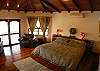 Master Bedroom with King bed, TV, ensuite bathroom, walk-in closet and balcony with view of the pool and beach.  Casa de Somers vacation rental in Esterillos near Jaco and Manuel Antonio.