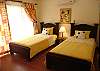 View of one of the three upstairs bedrooms, with twin beds, closet, AC and access to the terrace.