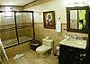 Master bathroom with shower and bathtub  at La Flor Rustico beachfront vacation rental in Jaco, Costa Rica