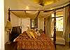 Gorgeous Master Bedroom with King size four poster bed with canopy, high vaulted ceiling, black-out curtains, armoire with TV and DVD, overlooking the ocean, at Hermosa Palms Villa La Costa vacation luxury rental in Playa Hermosa, Costa Rica