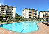 Large pool with plenty of lounge chairs and umbrellas at Costa Linda vacation rental condominiums in Jaco, walking distance to the beach.