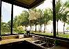 Kitchen with view of the pool, beach and palm trees at Hermosa Palms Villa La Costa luxury vacation rental in Playa Hermosa, Costa Rica.