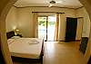 View of Master Bedroom from walk-in closet, looking out to pool area at Villa Las Monas vacation rental house near Jaco, Costa Rica