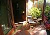 the private terrace from the Main Room with a hammock in wich you can enjoy the view of the garden and the sound of the river and the sea at Sonidos del Rio, Vacation Rental, Jaco Costa Rica.