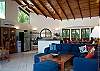 Comfortable living area with high ceilings and TV at Casa Milagro beachfront vacation rental villa in Jaco, Costa Rica