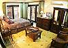 Master Bedroom with wrought iron and wood Queen bed, wooden armoire and chest of drawers, flatscreen TV and DVD and ensuite bathroom at La Flor del Paraiso vacation rental home in Jaco's only beachfront single-family home gated community.