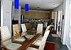 Dining table and kitchen behind at Casa Infinito luxury oceanview vacation rental at Valle Perdido in Playa Hermosa, Costa Rica