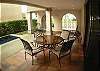 Terrace next to pool with charcoal BBQ grill, table with four chairs and lounge chairs at Casa Colonial vacation rental house in Hermosa Palms, Playa Hermosa, Costa Rica