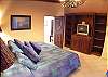 Master Bedroom overlooking pool area, with King size bed, TV and ensuite bathroom at beachfront Casa Mandolina, Jaco, Costa Rica