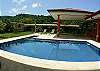 Romanesque style columns surround the pool with view of the rainforest mountains at Villa Las Monas vacation rental house near Jaco, Costa Rica