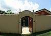 View of exterior wall and street gate at Villa Las Monas vacation rental home outside Jaco and near Los Suenos, Costa Rica
