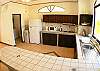 Kitchen with breakfast bar and adjacent laundry at Villa Las Monas vacation rental house near Jaco, Costa Rica
