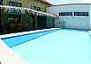 Pool and palm thatched terrace with table for 10 guests and gas grill at Casa Gris vacation rental house in Jaco, Costa Rica