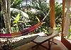 This is the private terrace from the Main Room with a hammock in wich you can enjoy the view of the garden and the sound of the river and the sea at Sonidos del Rio, Vacation Rental, Jaco Costa Rica.