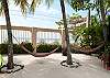 Hammocks on palm trees looking out to the beach at Casa Milagro beachfront vacation rental villa in Jaco, Costa Rica