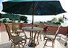 Large outdoor ocean view Terrace with table, chairs, large umbrella and lounge chairs at our MarArena beachfront vacation rental penthouse condo in Jaco, Costa Rica