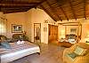 Guesthouse 1 with two Queen beds, TV and bathroom at Casa Milagro beachfront vacation rental house in Jaco, Costa Rica