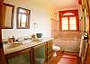 Second bathroom (shared between second and third bedrooms) with two sinks on a marble top, combination shower/jetted bathtub with tempered glass door at Villa Oceana vacation rental home in Esterillos, Costa Rica, half way between Jaco and Manuel Antonio.