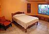 Bedroom with Double bed, ensuite bathroom and wooden blinds at Casa Miguel vacation rental in Jaco, Costa Rica, 8 minutes walking distance to beach and main street.