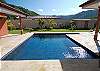 Beautiful swimming pool with natural rock terrace around, with views of surrounfing forested mountains at Casa Las Monas vacation rental house near Jaco, Costa Rica