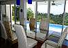 Dining table for 8 guests with tempered glass top at Casa Infinito luxury ocean view vacation rental home at Valle Perdido in Playa Hermosa, Costa Rica
